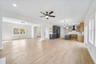 Unfurnished living room with ceiling fan, light hardwood / wood-style flooring, and sink