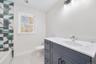 Bathroom with a shower, vaulted ceiling, vanity, and toilet