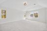 Spare room with light colored carpet and lofted ceiling