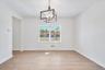 Unfurnished dining area with light wood-type flooring and an inviting chandelier