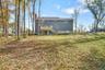 Rear view of house with a yard and a wooden deck