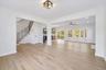 Unfurnished living room with ceiling fan with notable chandelier and light wood-type flooring