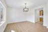 Unfurnished room featuring plenty of natural light, a notable chandelier, and light wood-type flooring
