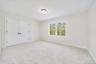 Unfurnished bedroom with light carpet and a closet