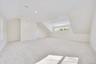 Bonus room with light carpet and vaulted ceiling
