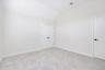 Carpeted spare room featuring vaulted ceiling