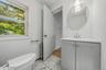 White vanity with a corner-fit countertop and undermount sink