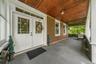 Covered porch featuring a wood-plank ceiling, white trim, and a gray floor