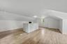 Spacious loft area featuring wood-finish flooring, recessed lighting, and a built-in half-wall partition
