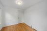 Hardwood flooring, painted walls, flush-mount ceiling light, and baseboard heating