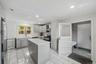 Kitchen featuring an island with a light-toned countertop, subway tile backsplash, stainless steel appliances, and recessed lighting