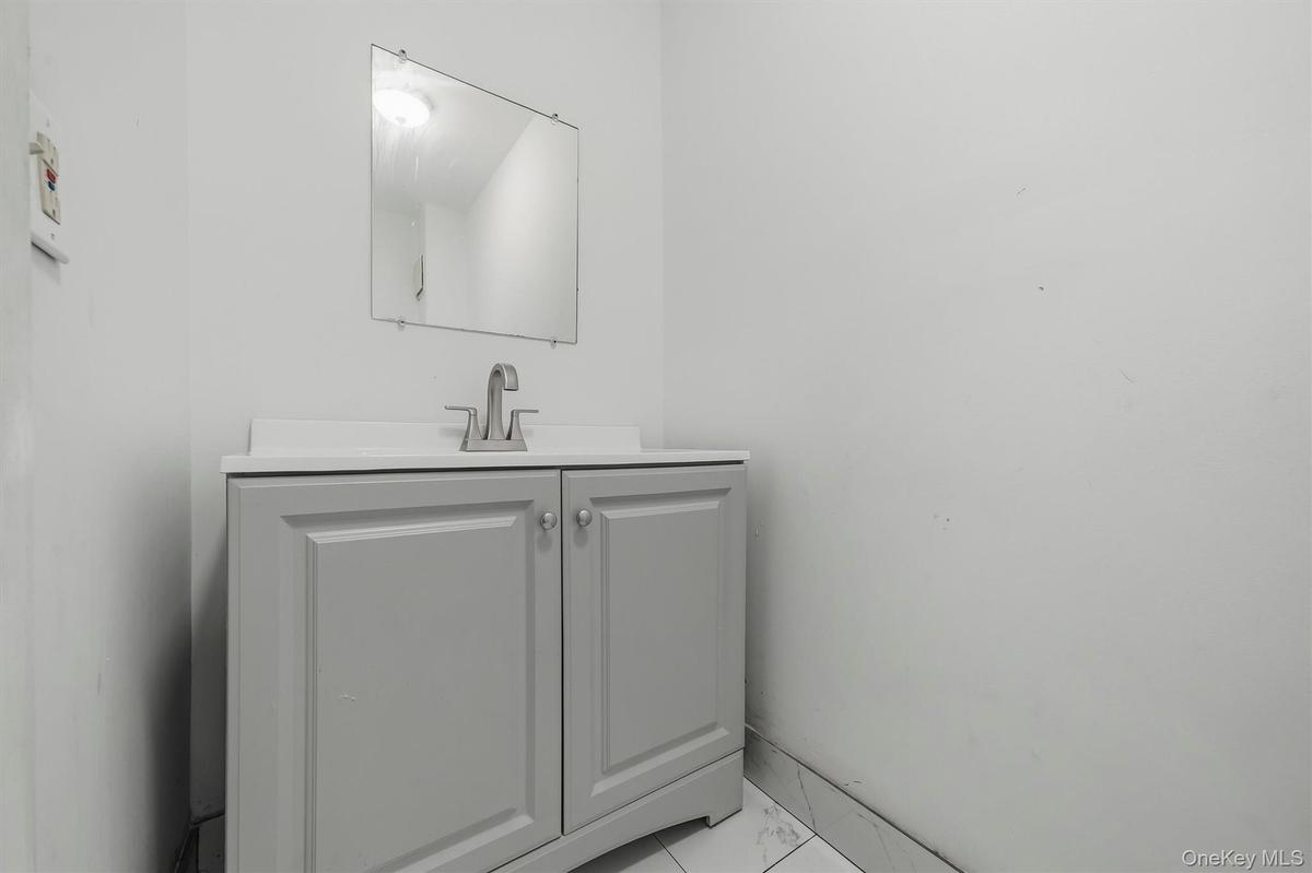 Freestanding vanity with panel cabinetry and brushed nickel hardware
