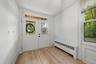 Wood-finish flooring, white walls, and a front entry with glass paneled doors
