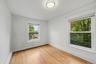 Hardwood flooring, two windows, ceiling-mounted light fixture, white walls, and white trim