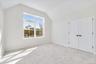 Unfurnished bedroom featuring lofted ceiling, light carpet, and a closet