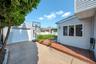 Detached garage with horizontal siding, concrete driveway, wood-look decking, and multiple exterior windows