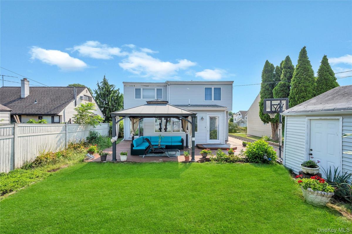 Rear view of property with a patio area, a gazebo, and an outdoor living space