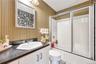 Full bath with wallpapered walls, vanity, combined bath / shower with glass door, and tile patterned flooring