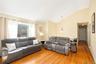Vaulted ceiling, wood-finish flooring, large window, two-panel interior door, and pendant lighting fixture