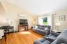 Living space with wood-finish flooring, vaulted ceiling, and window with natural light