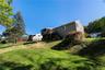 Expansive  backyard featuring established trees and green landscaping