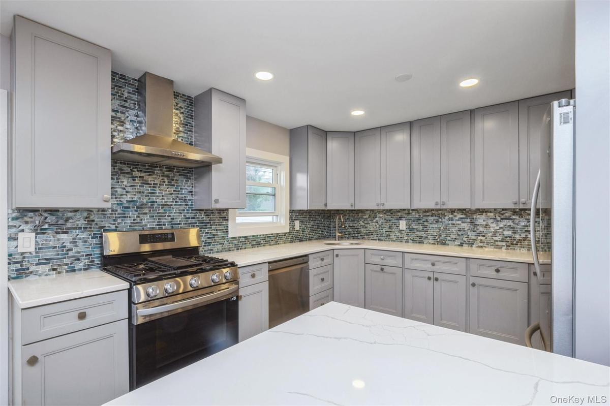 First floor renovated kitchen with quartz counter tops and stainless steel appliances.