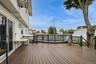 Deck next to permitted partially inground pool with fence and trek decking surrounding
