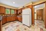 Wood cabinets, stone floor, door on right leads to laundry room, powder room, pantry and backyard.