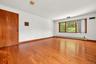 BR 2.  Oversized windows. Wood floors. Extraneous objects removed from photo.