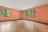 Large room with oversized windows and wood floors