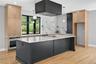 Kitchen featuring light stone countertops, stainless steel oven, decorative light fixtures, wall chimney exhaust hood, and recessed lighting