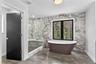 Bathroom with a marble finish shower, a freestanding tub, and recessed lighting
