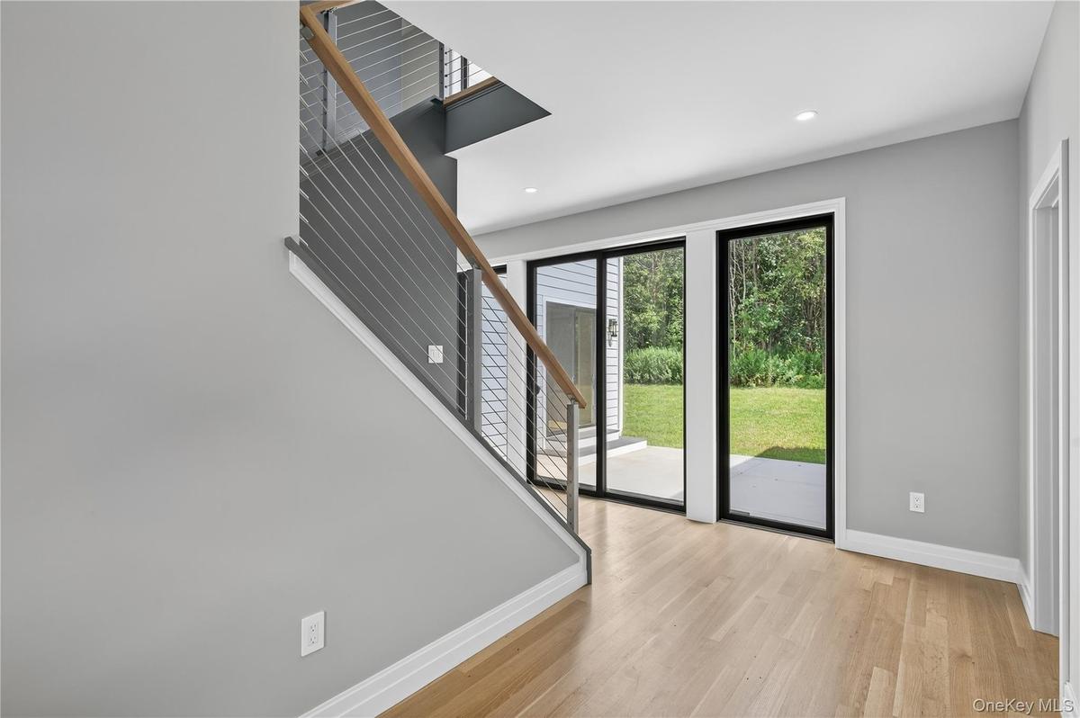 Foyer with light wood-style flooring, stairs, and recessed lighting
