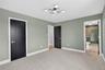 Unfurnished bedroom featuring ensuite bath, carpet flooring, and a chandelier