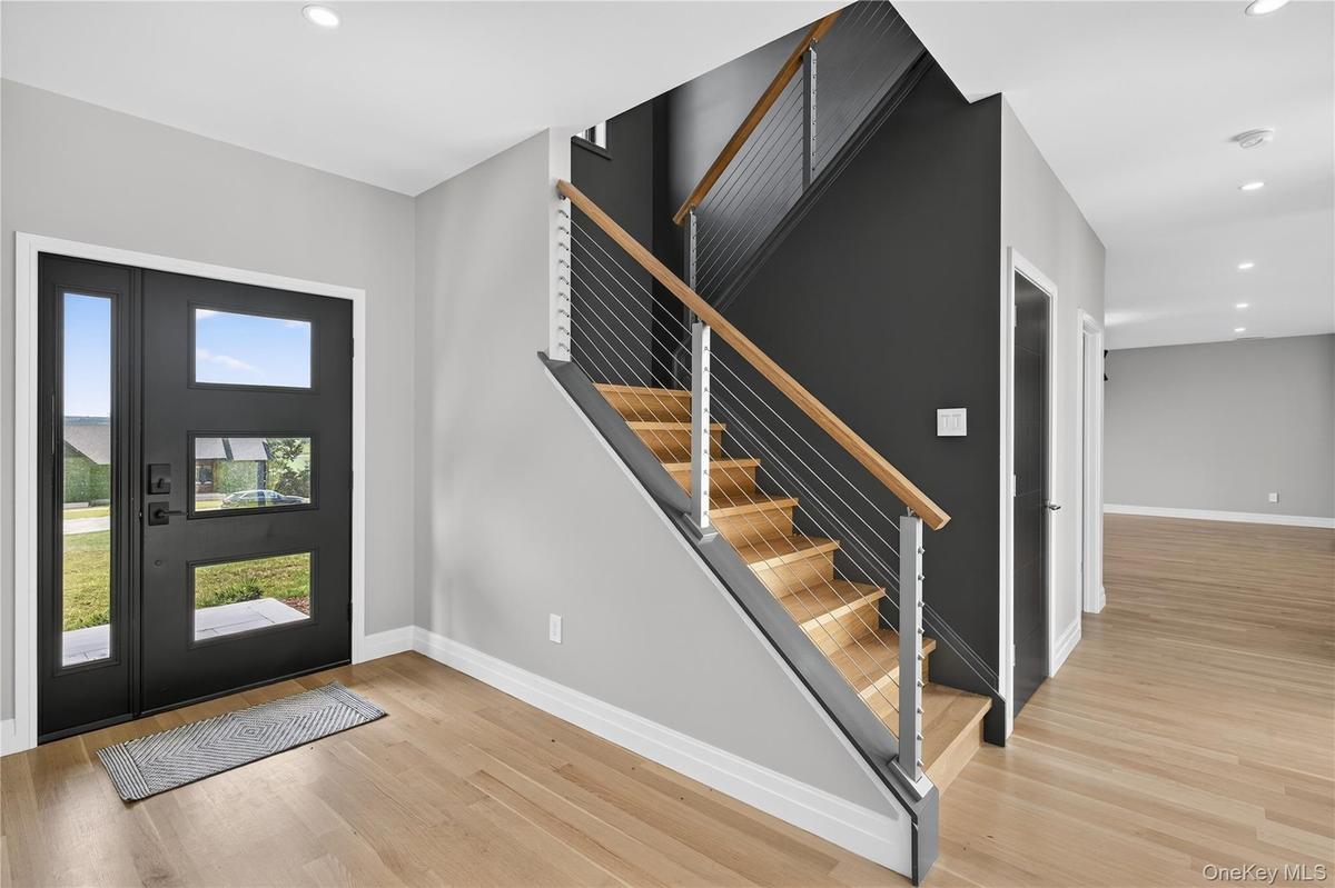 Entrance foyer with recessed lighting, light wood-type flooring, and stairway