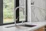 Kitchen view of a sink and light stone counters
