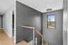 Corridor featuring an upstairs landing and light wood finished floors