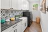 Enjoy a large Farmhouse Sink in your indoor custom Laundry Room with TONS of cabinetry and storage!