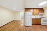 Kitchen featuring wood cabinetry, white appliances, and a stainless steel sink