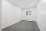 Recessed lighting illuminates a neutral painted interior with a window featuring security bars and baseboard heating