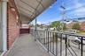 Brick exterior with a covered porch, concrete flooring, and decorative metal railings