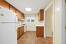 Compact kitchen with a built-in range, overhead cabinetry, and patterned flooring