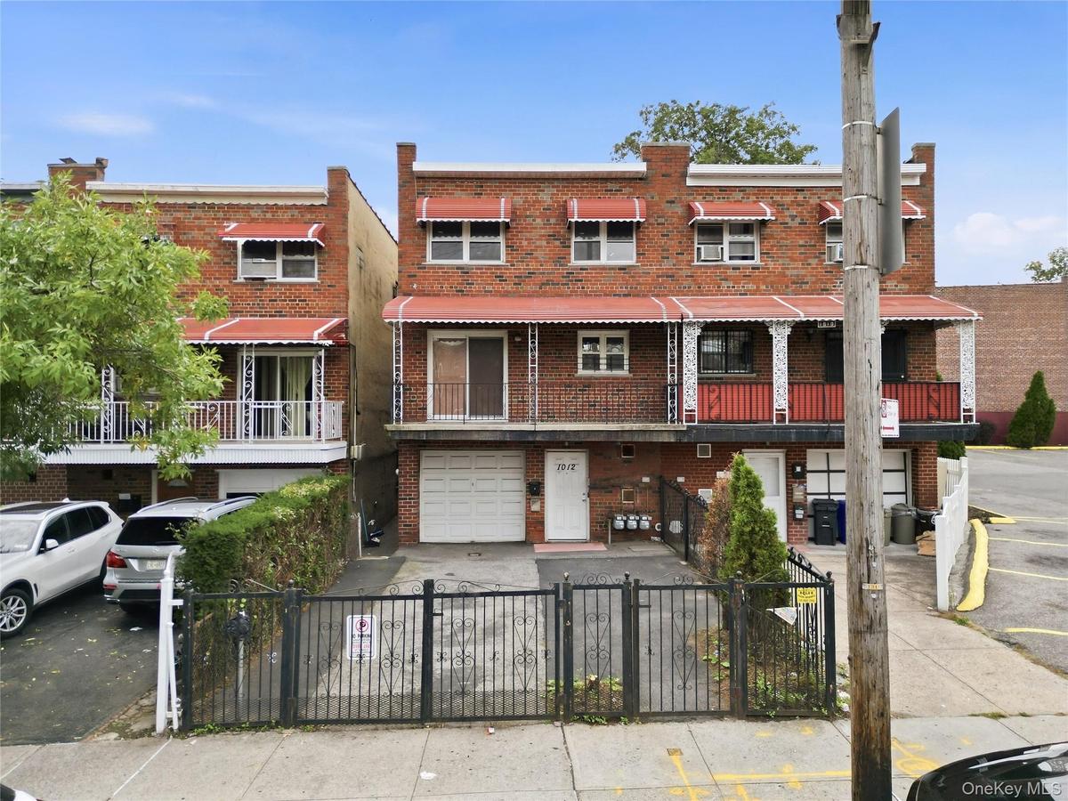 Brick exterior with multiple balconies and red awnings