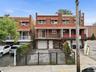 Brick exterior with multiple balconies and red awnings