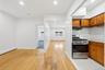 Hardwood flooring, recessed lighting, stainless steel gas range, wood cabinetry, and tiled backsplash