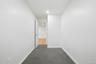 White painted walls, gray carpet, and a white interior door with a silver-tone knob