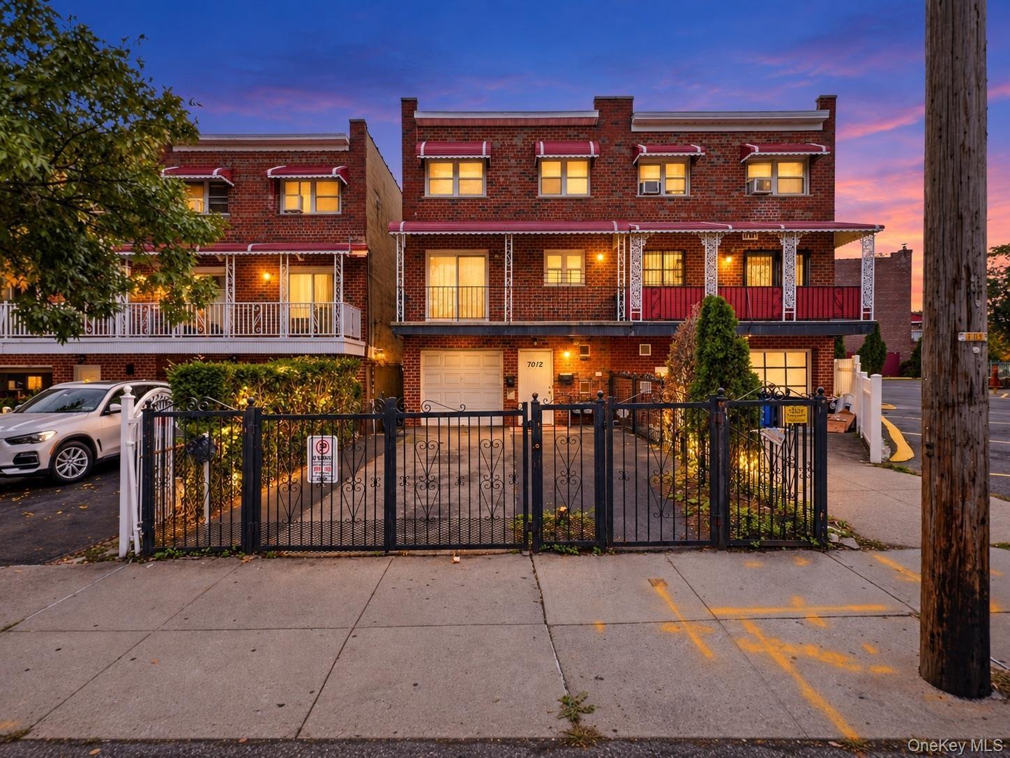 Brick facade with white and red awnings, decorative wrought iron fencing, and multiple balconies