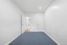 White painted walls with blue carpeting, recessed ceiling lighting, and white paneled doors