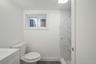 Full bathroom with vanity, a marble finish shower, toilet, and baseboards