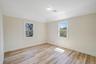 Empty room with healthy amount of natural light, light wood-type flooring, and baseboards